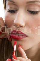 woman applying red lipstick