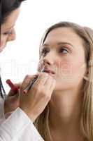 young pretty beautician applying lipstick