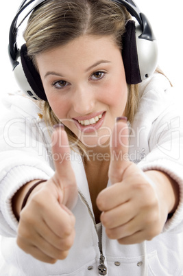 young model listening music with headphones and showing thumbs up