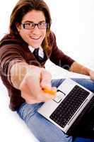 side pose of smiling man with laptop and pencil
