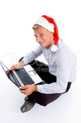 handsome man with christmas hat and laptop