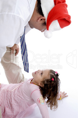 father wearing christmas hat playing with his daughter