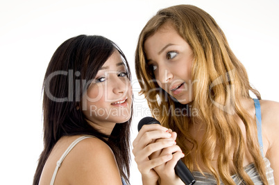 smiling models singing in microphone