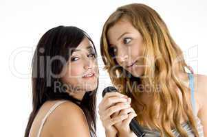 smiling models singing in microphone