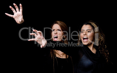 portrait of shouting young women showing hand gesture