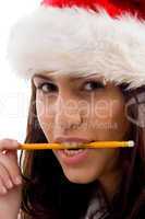 female wearing christmas hat holding pencil in mouth