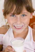 smiling girl with glass of milk looking you
