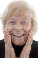 portrait of smiling old woman holding her face