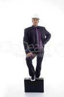 full body pose of architect with one leg on briefcase