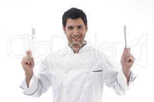 handsome chef holding knife and fork in hands