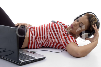 woman holding headphone and looking into laptop