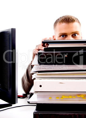 professional man peeping from files in office