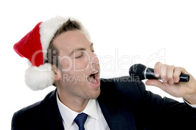 young man singing into microphone with santa cap
