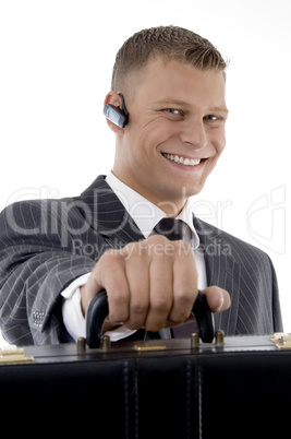 successful businessman with bluetooth and holding office bag