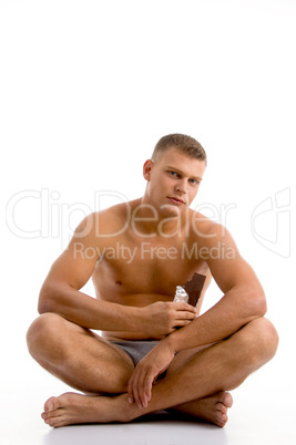 sitting muscular guy with chocolate