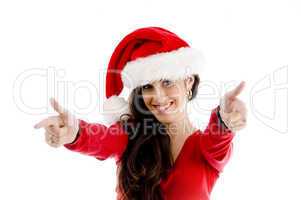 young woman with christmas hat pointing with both hands