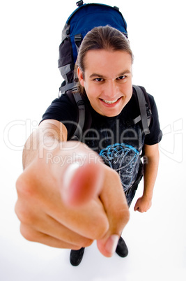 young traveler with bag pack pointing at camera