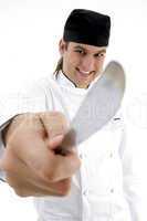 male chef showing kitchen tool with facial expressions