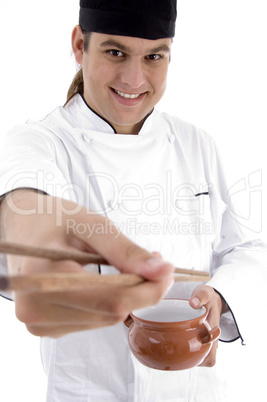 chef presenting chinese dish with chopstick