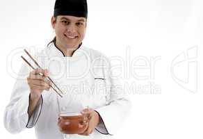 chef presenting chinese dish with chopstick