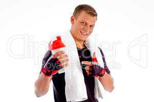 smiling muscular man pointing at water bottle