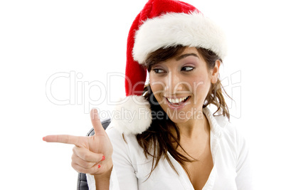 front view of smiling businesswoman in christmas hat pointing sideways