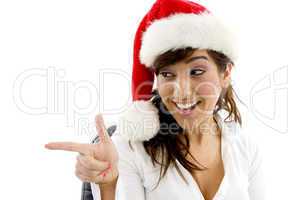front view of smiling businesswoman in christmas hat pointing sideways