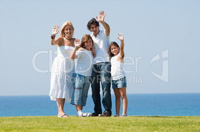 Family standing outdoors waving