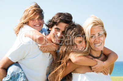 Couple giving children piggyback rides smiling