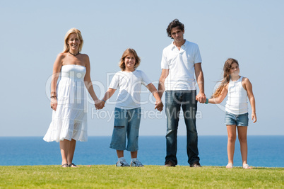 Family of four holding hands