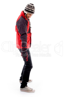 handsome young caucasian in winter clothes pointing towards his shoe