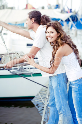 Cute young couple waiting at the boat harbour