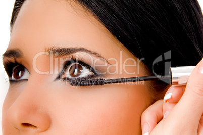 portrait of beautician applying maskara on woman's eye