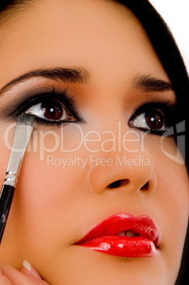 portrait of beautician doing eye make up of woman