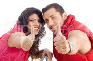cheerful young couple showing thumbs up
