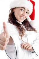 smiling young chef showing thumbs up and wearing red christmas hat