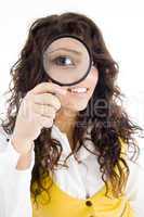 young girl holding magnifier and showing her magnified eye