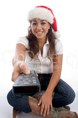 beautiful female wearing christmas hat and showing remote