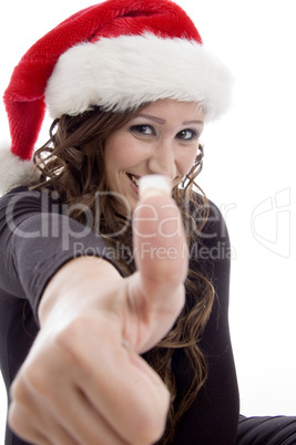 woman wearing christmas hat showing you good luck sign