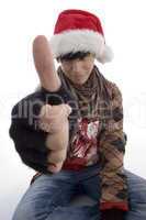 young boy wearing christmas hat showing thumb