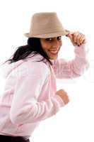 side pose of smiling model holding hat on white background