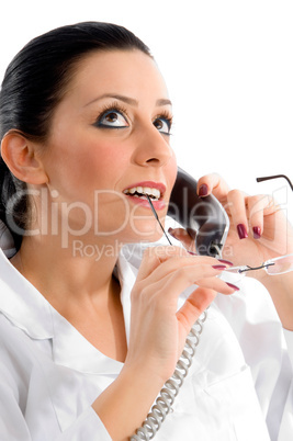 side pose of doctor talking on phone and looking upward on white background