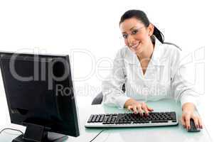 front view of smiling doctor working on computer on white background