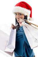 side pose of happy christmas model carrying shopping bags