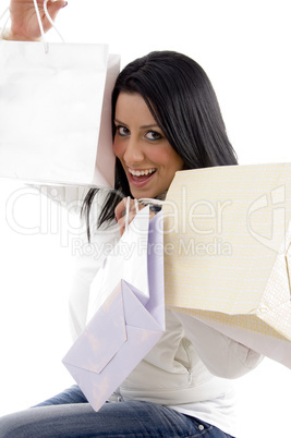 side view of pleased woman posing with shopping bags