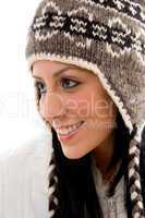 side pose of smiling woman wearing woolen cap on white background