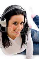 front view of smiling female listening music on white background