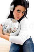 close view of female listening music and holding disco ball on white background