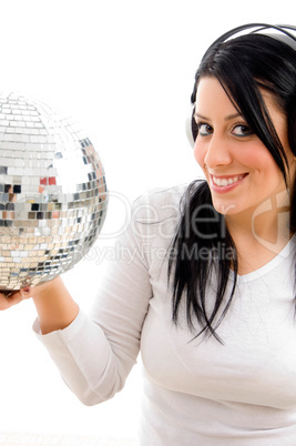 half length view of female listening music and carrying disco ball on white background