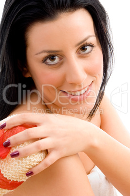 top view of smiling woman scrubbing her body against white background